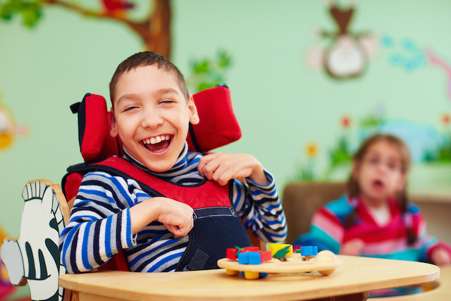 Deutsche Kinderhospiz Dienste Junge lacht im Rollstuhl Deutsche Kinderhospiz Dienste Junge lacht im Rollstuhl